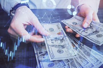 Multi exposure of financial graph drawing hologram and USA dollars bills and man hands. Analysis concept.