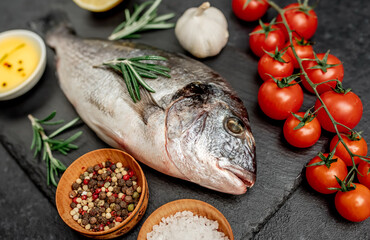 Raw dorado fish with spices on a stone background 