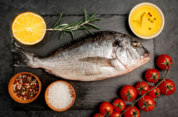 Raw dorado fish with spices on a stone background 