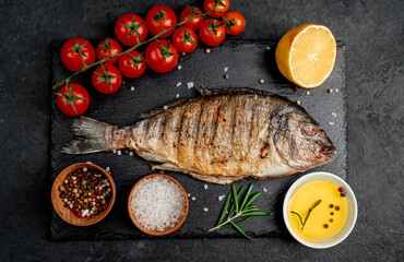 grilled dorado fish with spices on a stone background 