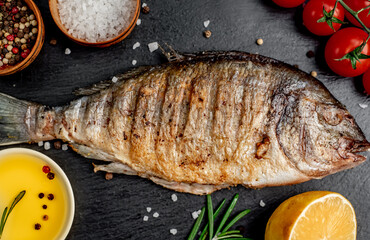 grilled dorado fish with spices on a stone background 