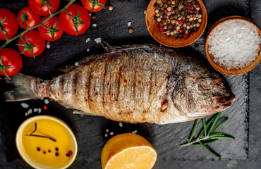 grilled dorado fish with spices on a stone background