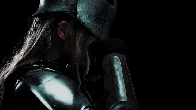 Profile of a young tough woman putting on a helmet, medieval ages, 4k