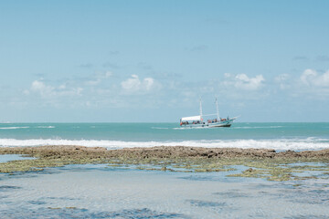 A touristic boat full of people in the ocean at the right