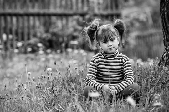 Lovely little girl playing in the park. Black and white photography.