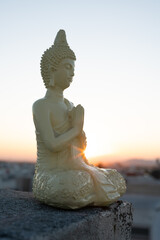 Buddha or Buda statue with sunrise or sunset at golden hour