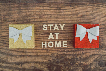 Fototapeta na wymiar holidays in lockdown due to covid, mini decorative Christmas presents with memo about staying at home