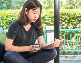 Young girl studying online from digital tablet in living room