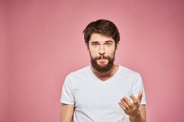 man in white t-shirt gesturing with his hands emotions fun pink background