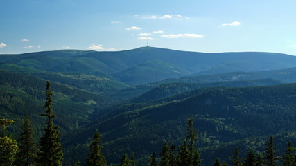 Landscape view of a hilly forest during a cloudy day with Praded transmitter on a hill in the...