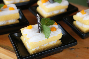 Slice of delicious vanilla cake on wooden table.