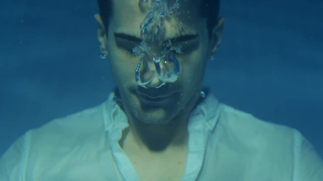 male model underwater. air bubbles come out of the nose. underwater shooting.