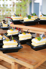 Slice of delicious vanilla cake on wooden table.