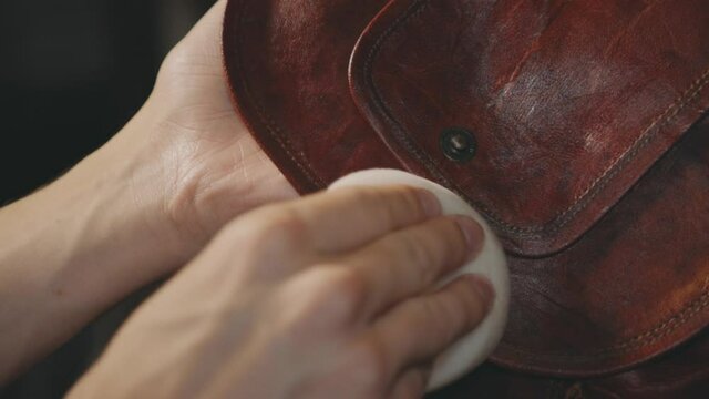Hand Image Polishing The Flap Of A Vintage Leather Bag. - High Angle Shot