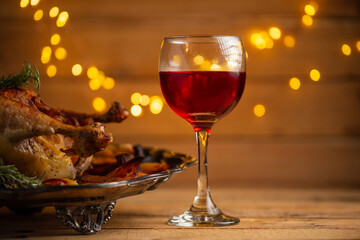 Glass of red wine on dish with baked turkey and potato background. Traditional recipe. Concept of tasty homemade food. Thanksgiving or Christmas dinner.