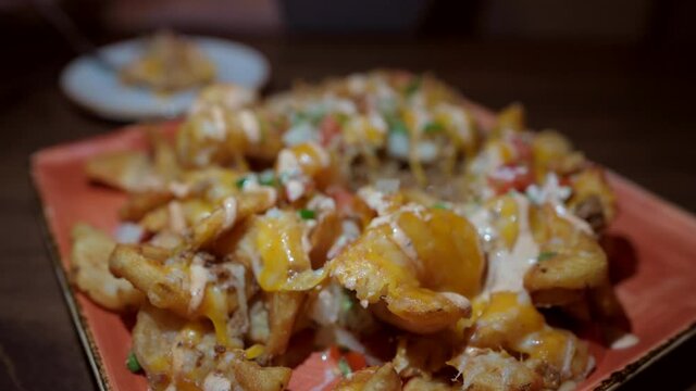 This Closeup Video Shows A Fork Digging Into Delicious Irish Potato Nachos, Covered With Mouth Watering Ingredients.