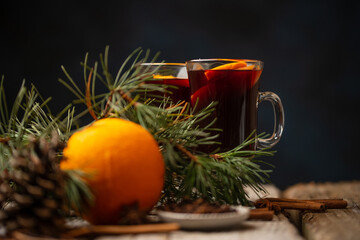 Glasses with aromatic hot mulled wine with original festive christmas composition on rustic wooden table. Tasty winter alcoholic drink.