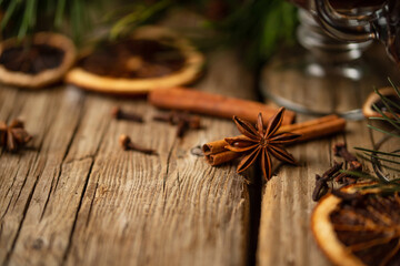 Winter Christmas composition with spruce branch, dried orange and spices on wooden background. Festive wallpaper. Idea for decoration. Close-up.