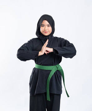 A Hooded Woman Wearing A Pencak Silat Uniform With A Green Belt Performs Respectful Hand Gestures On The Isolated Background