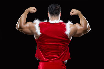 Back view of young Santa Claus showing off his strong biceps isolated on black background