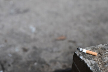 Cigarette placed on the floor. Selective focus