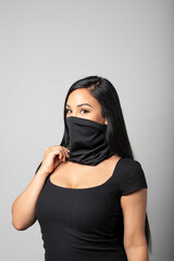 Mixed-Race woman wearing a black gaiter. Studio shot on white.