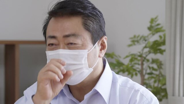リビングで咳をする中高年男性