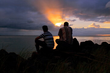 Fototapeta na wymiar two friends are enjoying sunset on ganges river, diamond harbour, west bengal in india