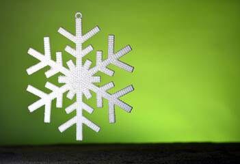 Artificial snowflake with sparkling ornaments, fuzzy background