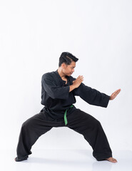 a man wearing a pencak silat uniform with a red belt performed a side stance movement on the isolated background