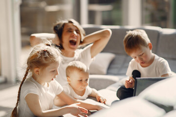 Obraz premium Coronavirus theme. Mother with children. Family stay at home. Kids watchs a cartoons.