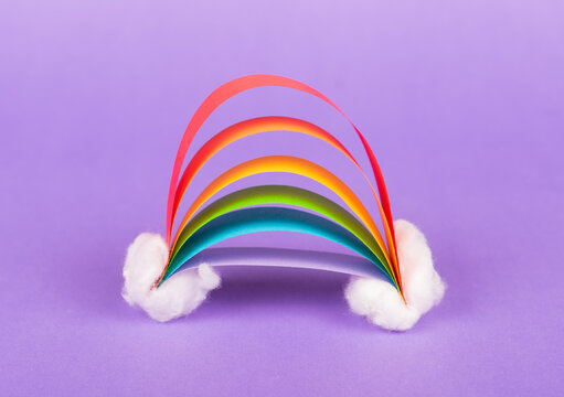 Handmade Kids Rainbow with Clouds made of Paper and Cotton on purple background