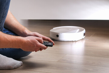 The robot vacuum cleaner cleans under the bed.