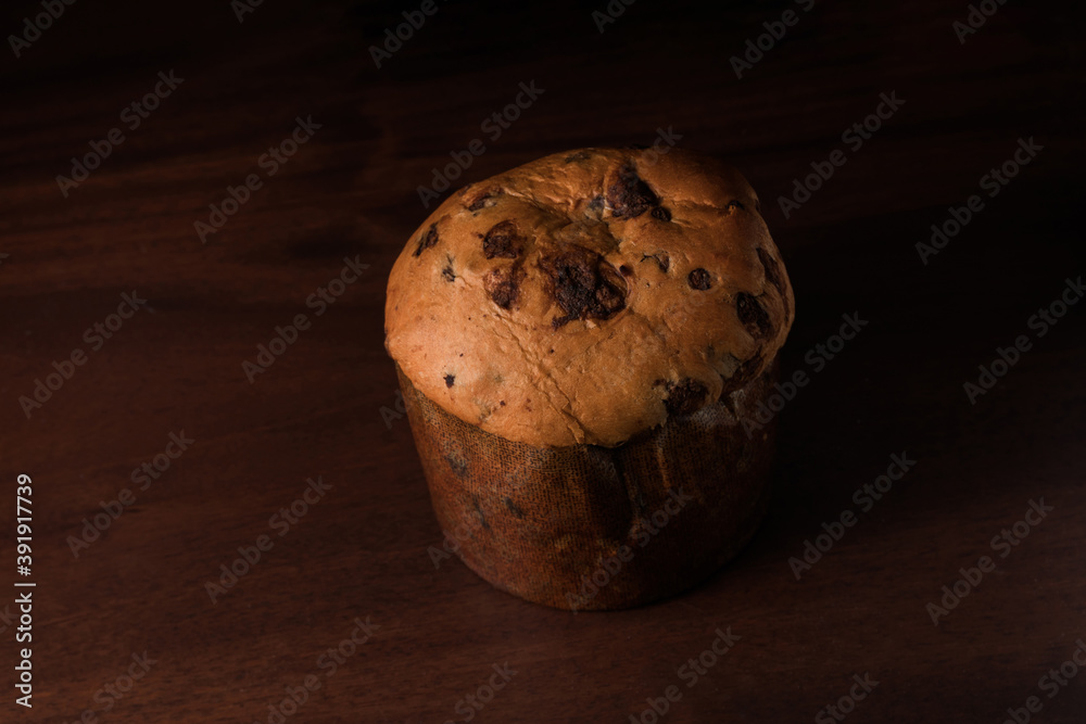 Wall mural chocolate panettone isolated on dark wooden background. traditional Italian dessert for Christmas