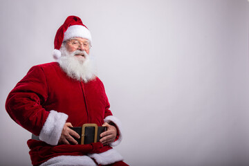 Happy Santa Claus, sat with hands in belt in white background