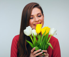 Young woman in red dress holding tulips flowers in front of herself