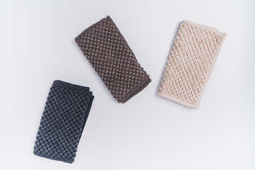 3 small kitchen towels, with recycled material in light brown, dark brown, and dark blue color. On the white background surface