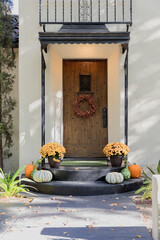 brown front door with a holiday wreath and potted flowers great the vistor