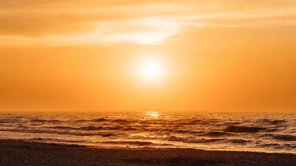 Fototapeta na wymiar Orange sunset at a beach in the summer