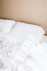 Crisp with bedsheets in a beige bedroom