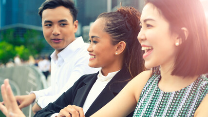 Obraz premium Three asian young friends standing outdoor in the city talking, smiling and enjoying city life