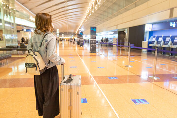 Go to トラベルでマスク姿で空港にいるアジアの若い女性