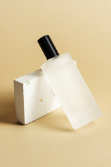Blank perfume glass bottle against a terrazzo podium