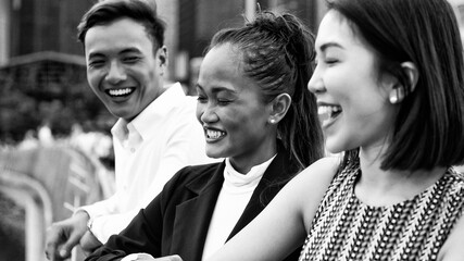 Three asian young friends standing outdoor in the city talking, smiling  and enjoying city life