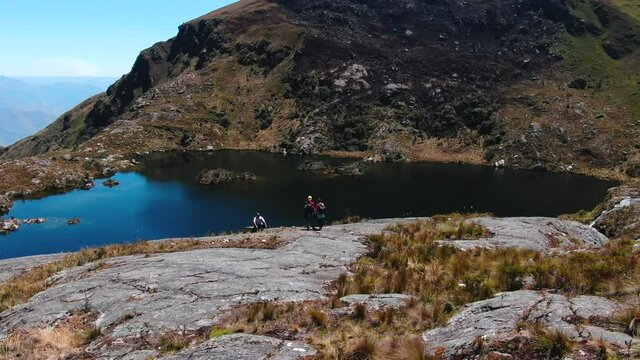 Tourists admiring the 1st lagoon of Pichgacocha from Ambo, Huanuco, Peru in the Andes mountains. 4k aerial drone footage, dolly out and boom/jib up wide angle shot.