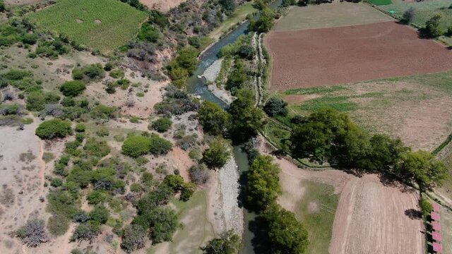 4k daytime aerial drone footage over the river of  Higueras near Kotosh archeological site from Huanuco in Peru. Dolly in and tilt up wide angle shot.
