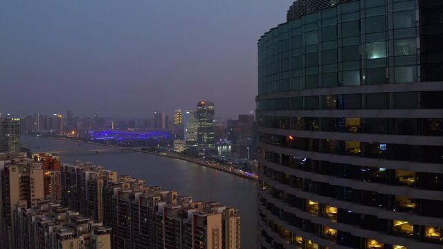 View of Guangzhou pearl river with numerous living block apartments and office buildings on a late colorful sunset. Aerial shot.