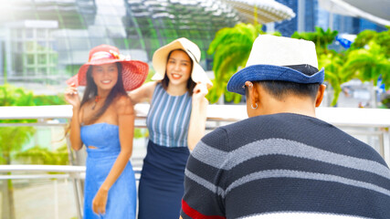 Three asian young friends enjoy outdoor time taking pictures along the city streets