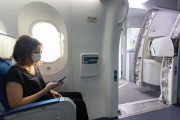Go to トラベルでマスク姿で飛行機に乗るアジアの若い女性