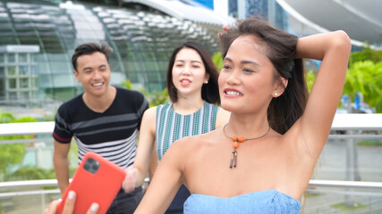 Three asian friends relaxing walking along city streets